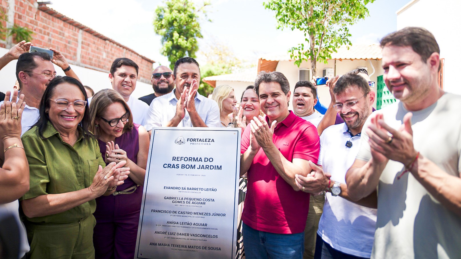 grupo de pessoas atrás da placa de inauguração do cras